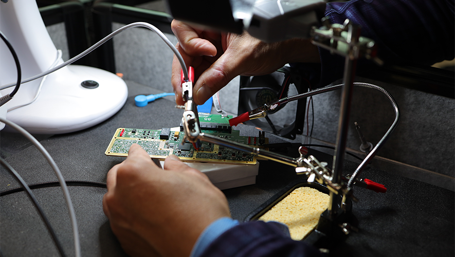 A photo of a person working on an electronic device.