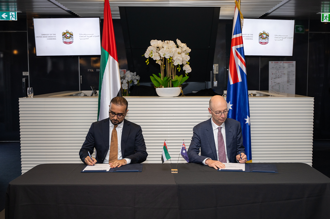 A photo of two people signing a document.
