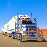 A photo of a large truck driving through an Australian landscape.