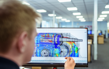 A photo of a person looking at a design on a computer screen.