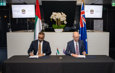 A photo of two people signing a document.