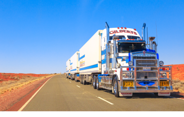 A photo of a large truck driving through an Australian landscape.